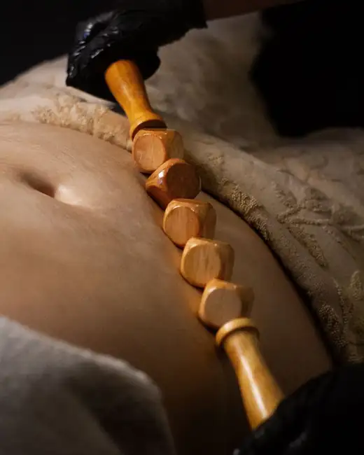 Massage du ventre avec un rouleau de madérothérapie